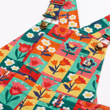Close up of the metal clasps on the Frugi organic cotton ethel flared dungarees with rectangle flower stamps design.