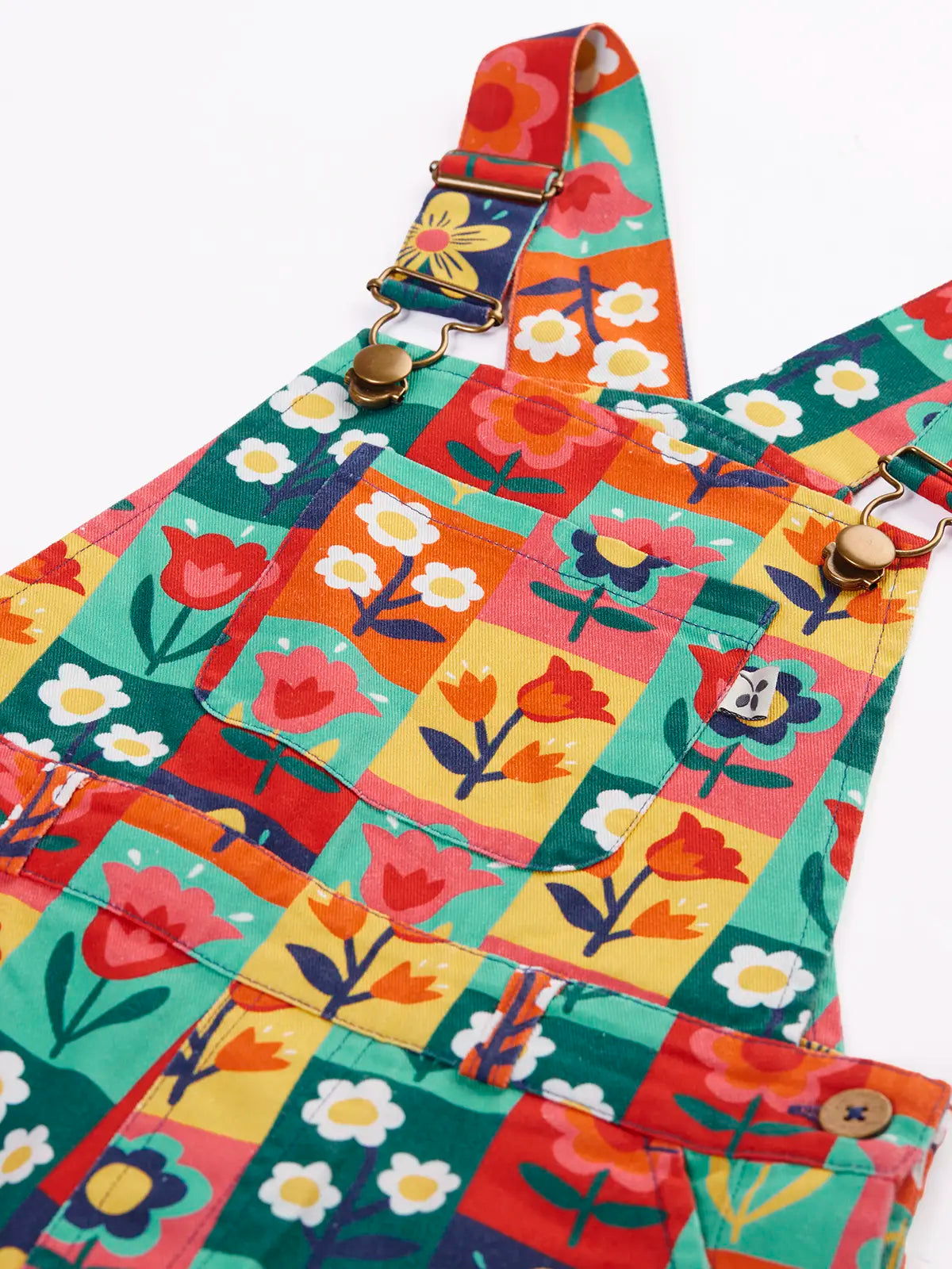Close up of the metal clasps on the Frugi organic cotton ethel flared dungarees with rectangle flower stamps design.