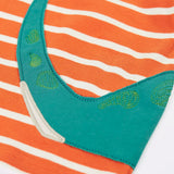 Close up of the back of the Frugi organic cotton felix long sleeve orange breton stripe top with teal nessie wrap around applique, showing it's tail. 