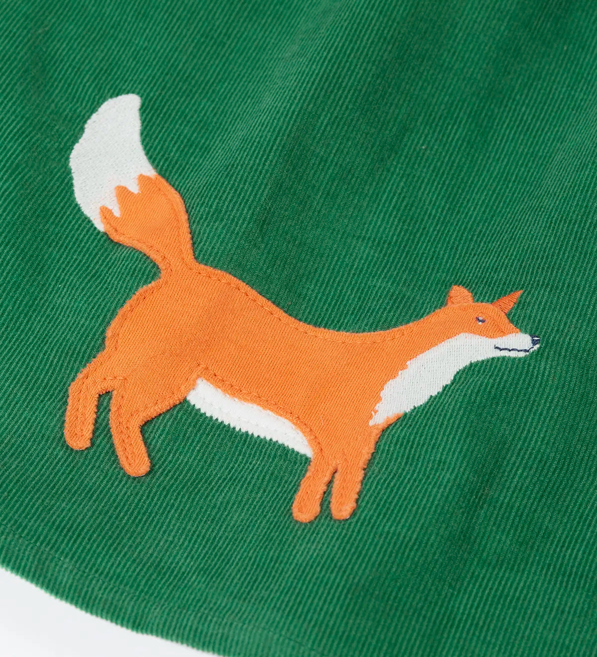 Close up of the fox applique on the hemline of the Frugi organic cotton peony holly green corduroy dress.