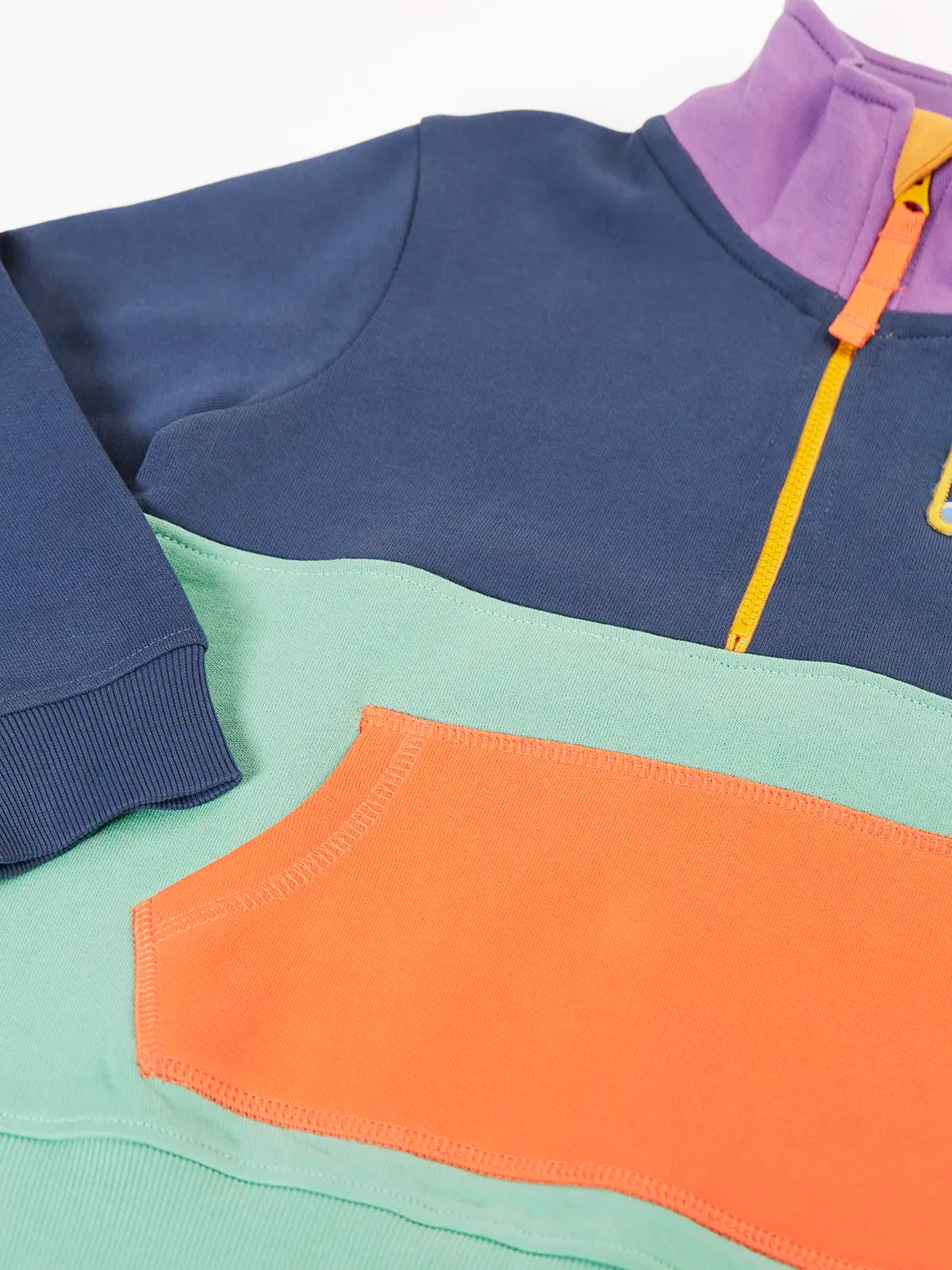 Close up of the orange kangarro pocket on the Frugi organic cotton half zip sweatshirt hotchpotch wildlife.