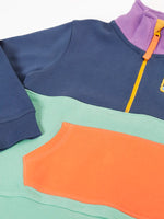 Close up of the orange kangarro pocket on the Frugi organic cotton half zip sweatshirt hotchpotch wildlife.