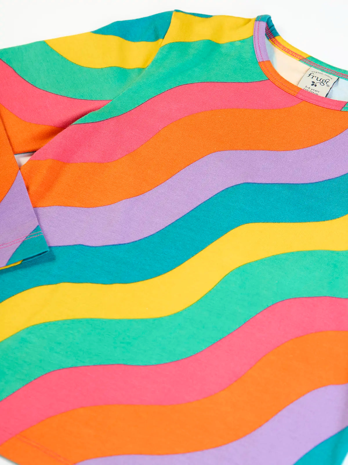 Close up of Frugi rainbow ric rac organic cotton bryher top. Long sleeved kids top with yellow, blue, lilac, orange, pink and green ric rac stripes. 