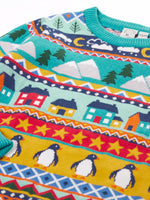 Close up of the patterns on the shoulder of the Frugi festive fair isle organic cotton jumper. Multicoloured fairisle design featuring penguins, stars, houses, mountain, trees, clouds and snowy clouds.