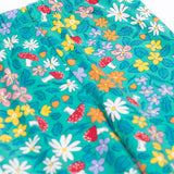 A close up of the Frugi Libby leggings with a wild woods, botanical design on a green background. The leggings have a slim elasticated waist band.