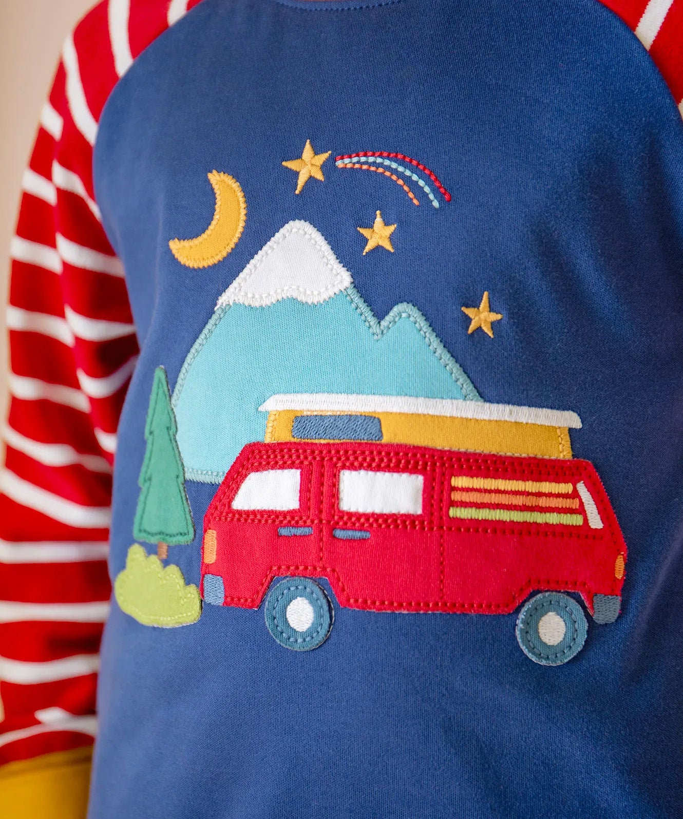 A close up of the campervan applique detail on the front of the Frugi jamie jim jams, being worn by a child.