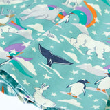 Close up of the print details on the Frugi GOTS organic cotton sofia skater dress in polar aurora. Blue background with and all over print featuring artic animals among star and colourful swishes. 