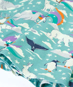 Close up of the print details on the Frugi GOTS organic cotton sofia skater dress in polar aurora. Blue background with and all over print featuring artic animals among star and colourful swishes. 