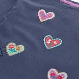 Close up Frugi bethany organic cotton long sleeved child's navy top with heart applies with floral embroidery details.