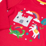 Close up of Frugi red organic cotton adventure magic applique long sleeved top with castle, rainbow, tree horse and nessie appliques on the front. 