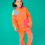 Frugi organic cotton Malpas joggers - in a salamander orange with flower applique details on the lower leg and side pockets on the lower leg and side.
