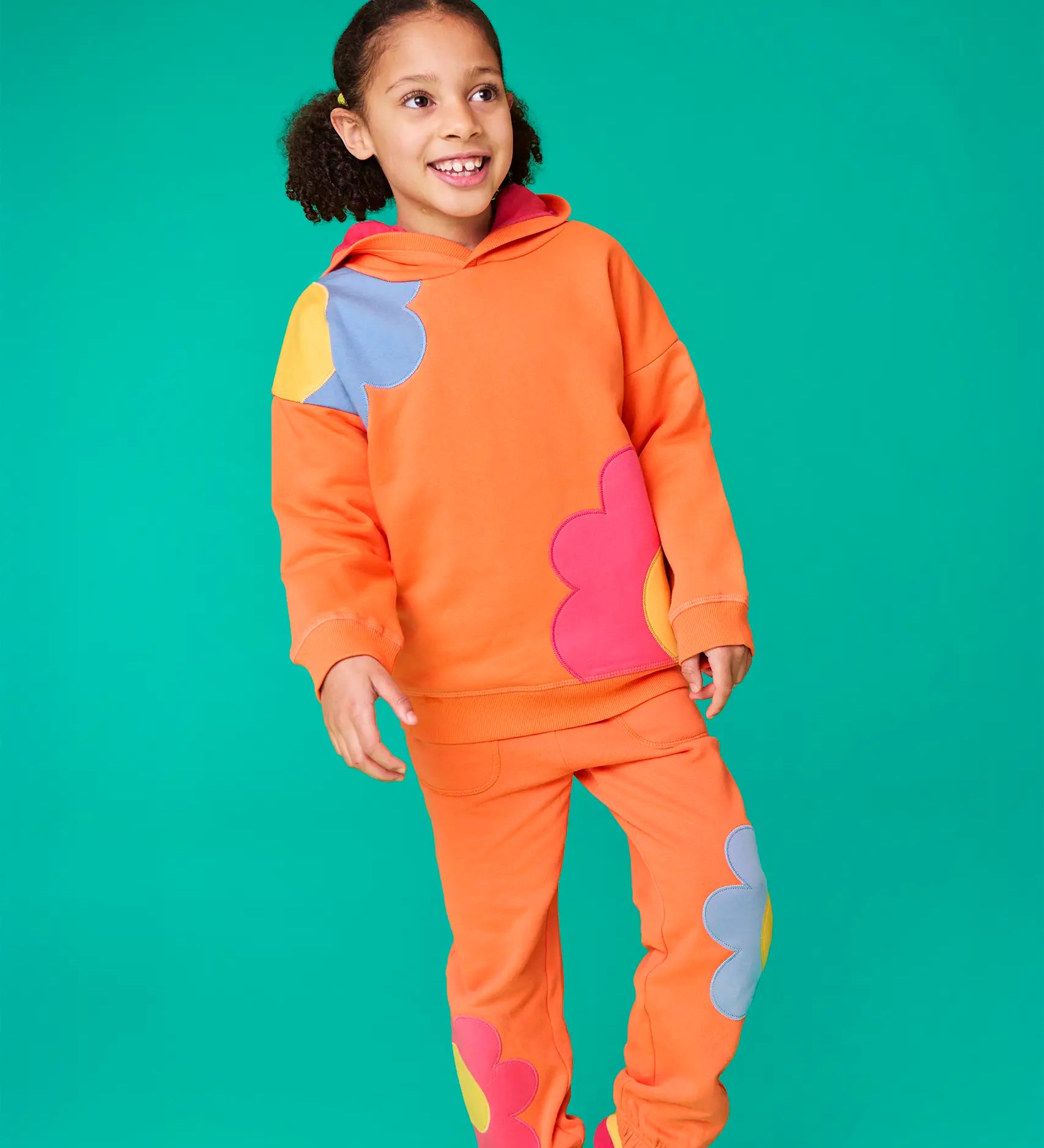 Frugi organic cotton Malpas joggers - in a salamander orange with flower applique details on the lower leg and side pockets on the lower leg and side.