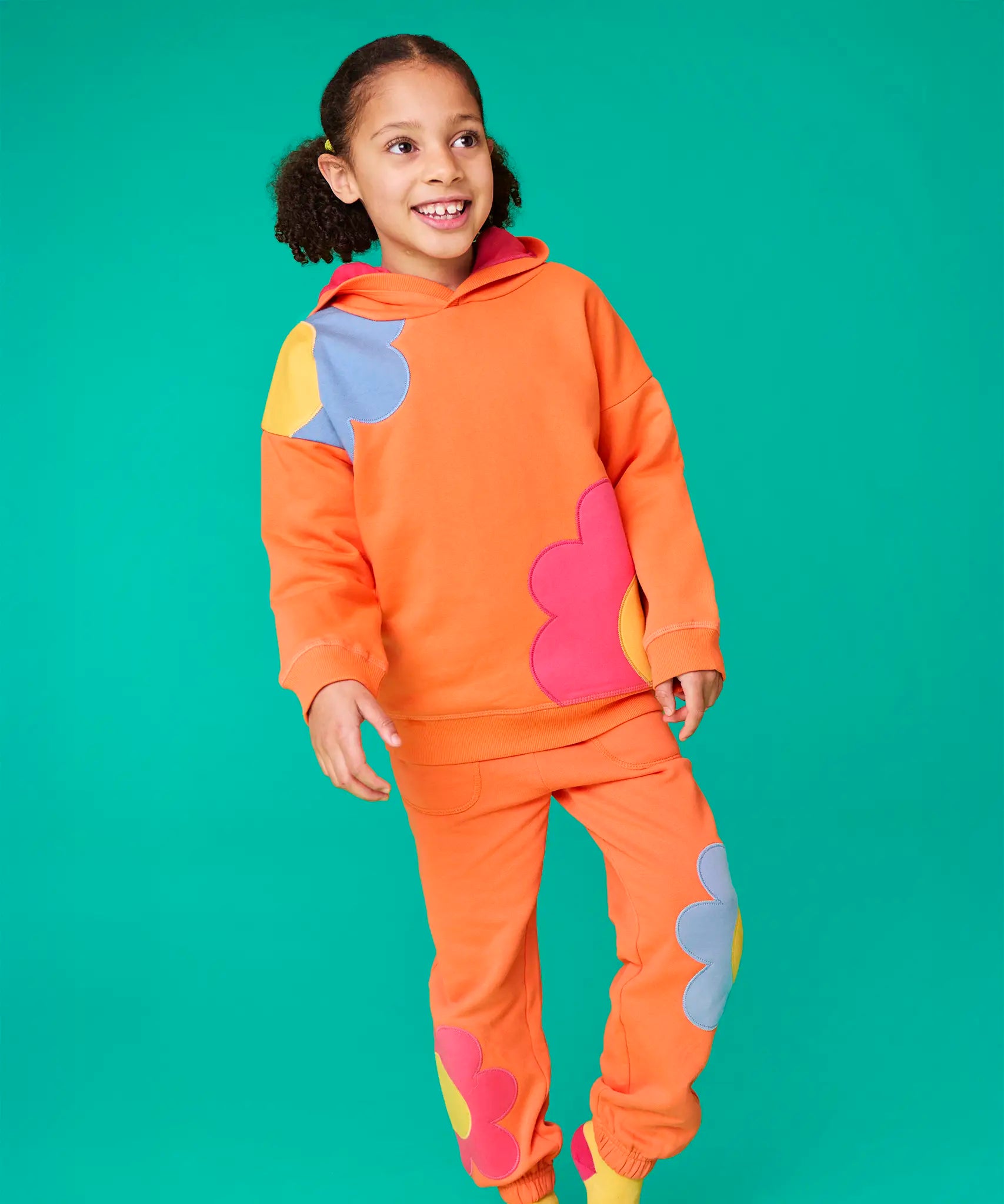 Frugi organic cotton Malpas joggers - in a salamander orange with flower applique details on the lower leg and side pockets on the lower leg and side.
