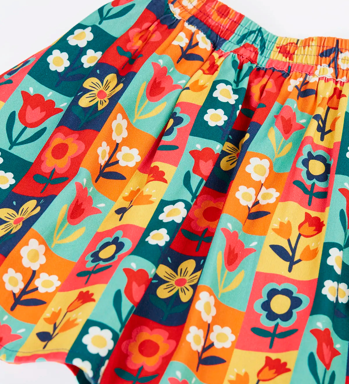 Close up of the Frugi organic cotton marta twill flower stamps skirt. Multi coloured rectangles with flowers. 