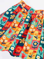 Close up of the Frugi organic cotton marta twill flower stamps skirt. Multi coloured rectangles with flowers. 