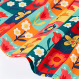 Close up of the hemline of the Frugi organic cotton marta twill flower stamps skirt. Multi coloured rectangles with flowers. 