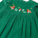 Close up of the robin, mistltoe, holly and toadstool festive details on the front of the Frugi organic cotton maud holly green corduroy dress.