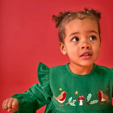 Close up of the embroidery on the front of the Frugi organic cotton maud holly green corduroy dress being worn by a child.