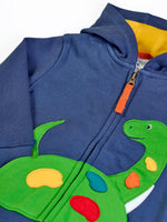 Close up of the green nessie applique on the front of the Frugi organic cotton carbis navy kids hoodie. The zip has an orange pull tab.