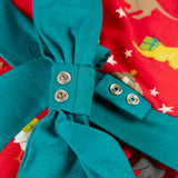 Close up of the poppers on the detachable teal bow that comes with the Frugi organic cotton pink party skater dress in a pet paw-ty print.