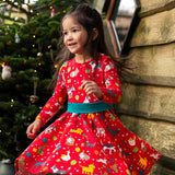 Child twirling wearing the Frugi organic cotton pink party skater dress in a pet paw-ty print featuring pets wearing party hats surrounded by wrapped gifts and balloons. 