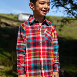 Child wearing the Frugi organic cotton festive check hector long sleeve shirt with chest pocket.