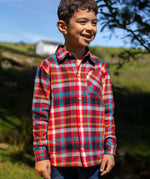 Child wearing the Frugi organic cotton festive check hector long sleeve shirt with chest pocket.