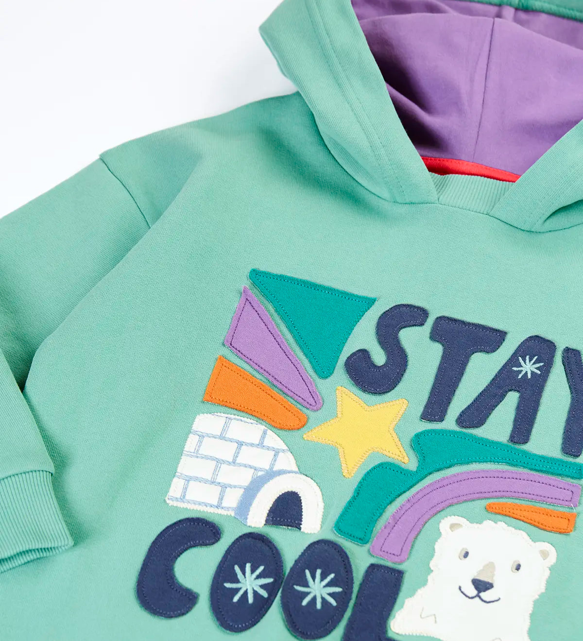 Close up of the Frugi organic cotton ria hoodie dress in moss green with a stay cool design applique on the front and a purple lined hood.