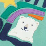 Close up of polar bear applique on the front of the Frugi organic cotton ria hoodie dress in moss green with a stay cool design applique on the front and a purple lined hood.