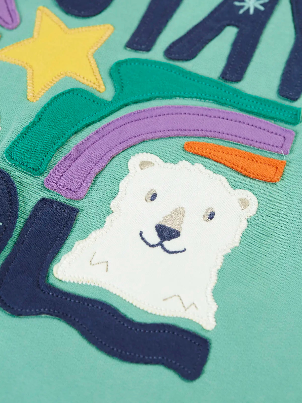 Close up of polar bear applique on the front of the Frugi organic cotton ria hoodie dress in moss green with a stay cool design applique on the front and a purple lined hood.