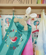 Close up of Senger rabbit soft toy in the Frugi organic cotton Christmas stocking. Striped teal quilted style stocking with a robin wreath embroidery detail and hanging loop hung up in the Babipur playroom.