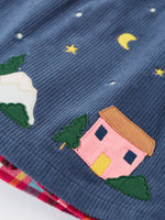 Close up of the pink house applique on the Frugi organic cotton rosalie reversible dress hemline.