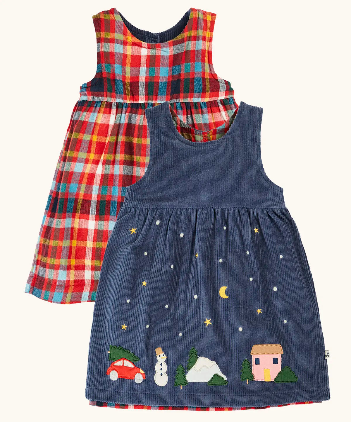 Frugi organic cotton rosalie reversible dress, one side in navy corduroy with appliques on the hemline and snow and stars on the skirt. One side in festive multicoloured check