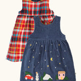 Frugi organic cotton rosalie reversible dress, one side in navy corduroy with appliques on the hemline and snow and stars on the skirt. One side in festive multicoloured check