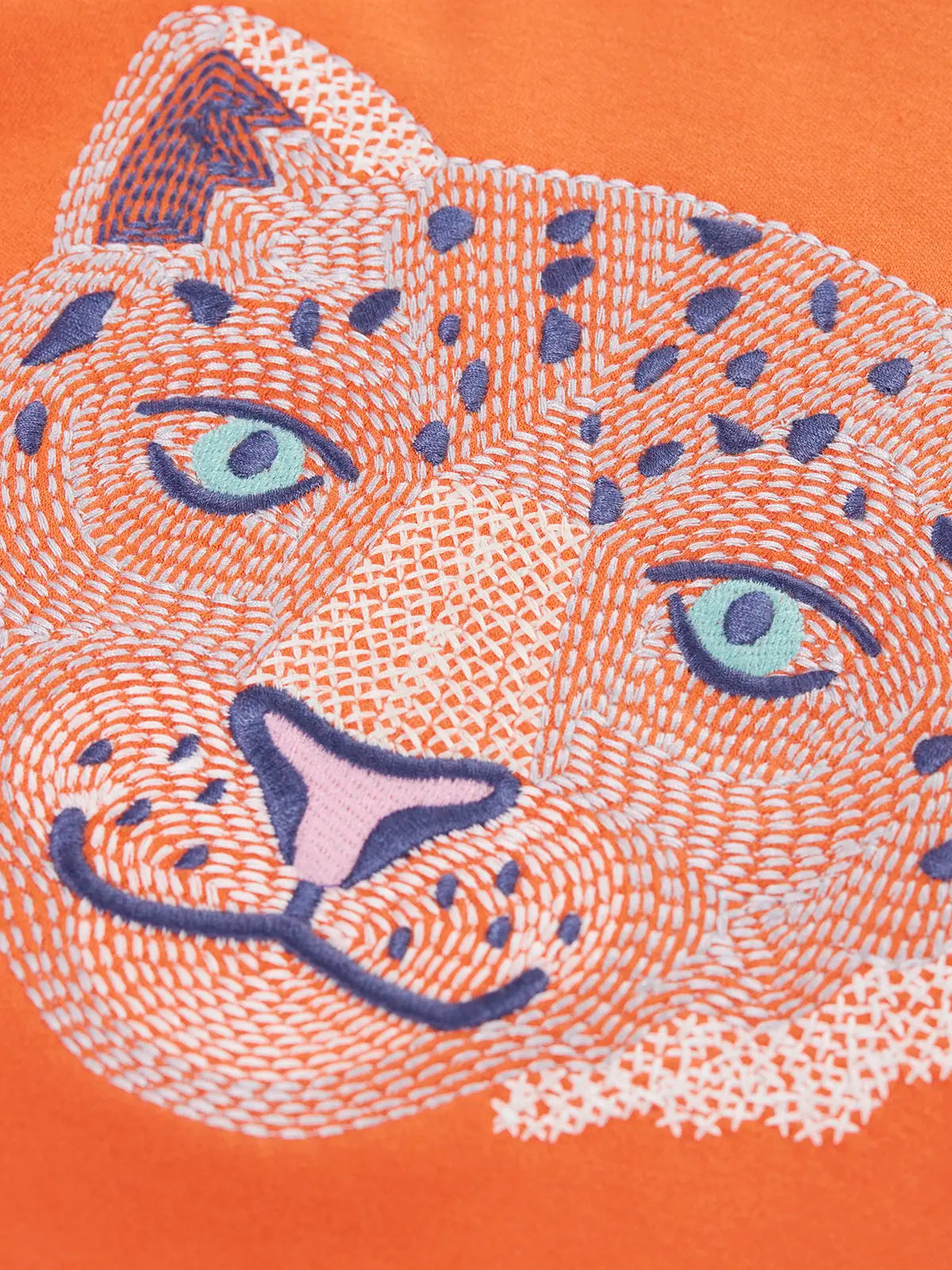 Close up of the embroidered snow leopard Frugi organic cotton salamander orange long sleeve top.
