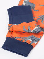 Close up of the navy extendable leg cuffs on the trousers from the Frugi organic cotton sundown kids long sleeve pyjama set with a leopard leap print. 