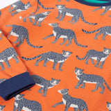 Frugi organic cotton sundown kids long sleeve pyjama set with a leopard leap print. Orange long sleeved pyjama top and matching trousers featuring an all over repeat print of grey leopards with navy cuffs and neck trim.