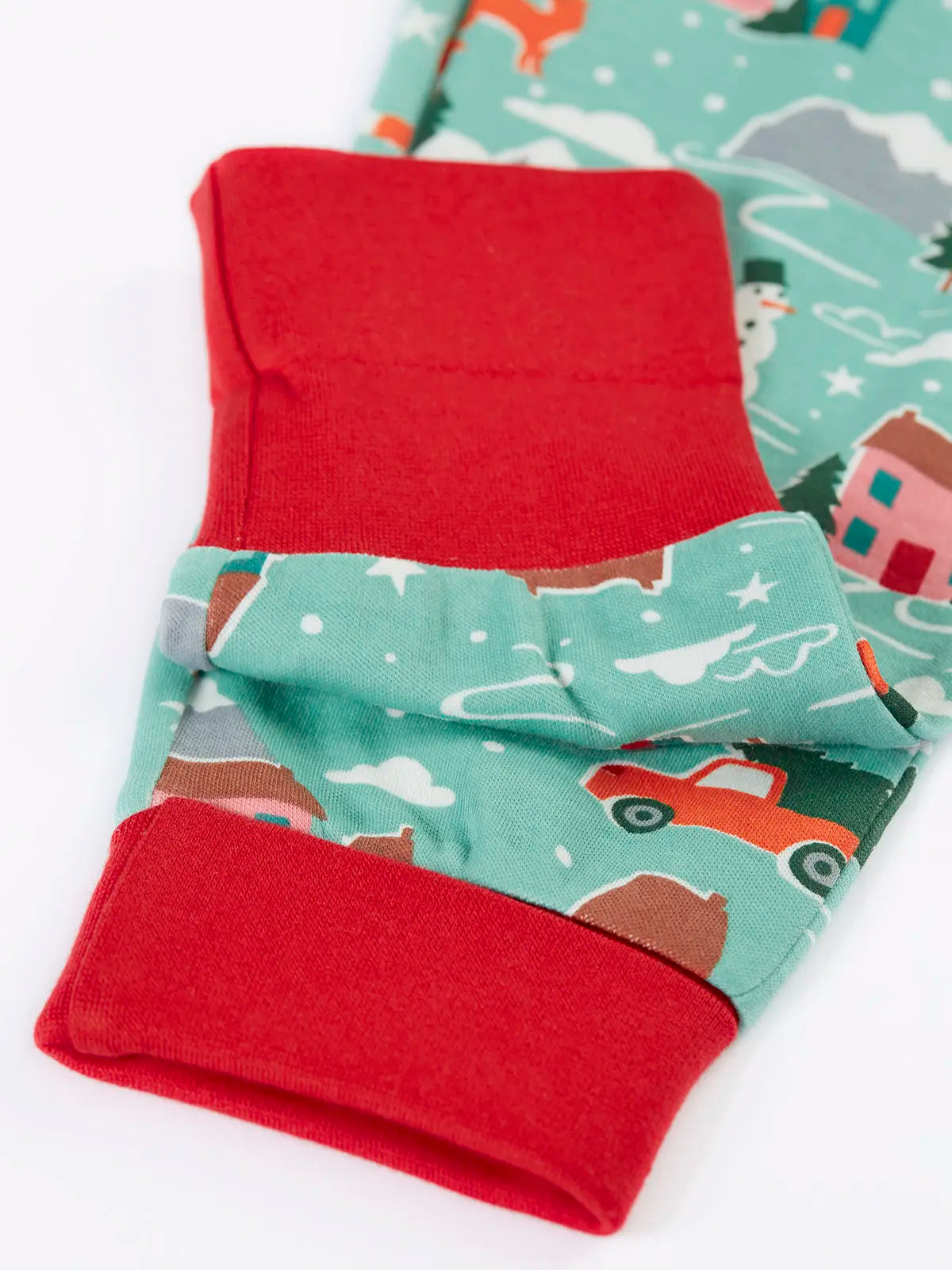 Close up of the red contrast extendable cuffs on the Frugi organic cotton sundown long sleeved pyjamas in winter drives print. 