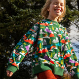 Child wearing the Frugi GOTS organic cotton superb sweatshirt with rescue trails print with rust orange corduroy trousers.