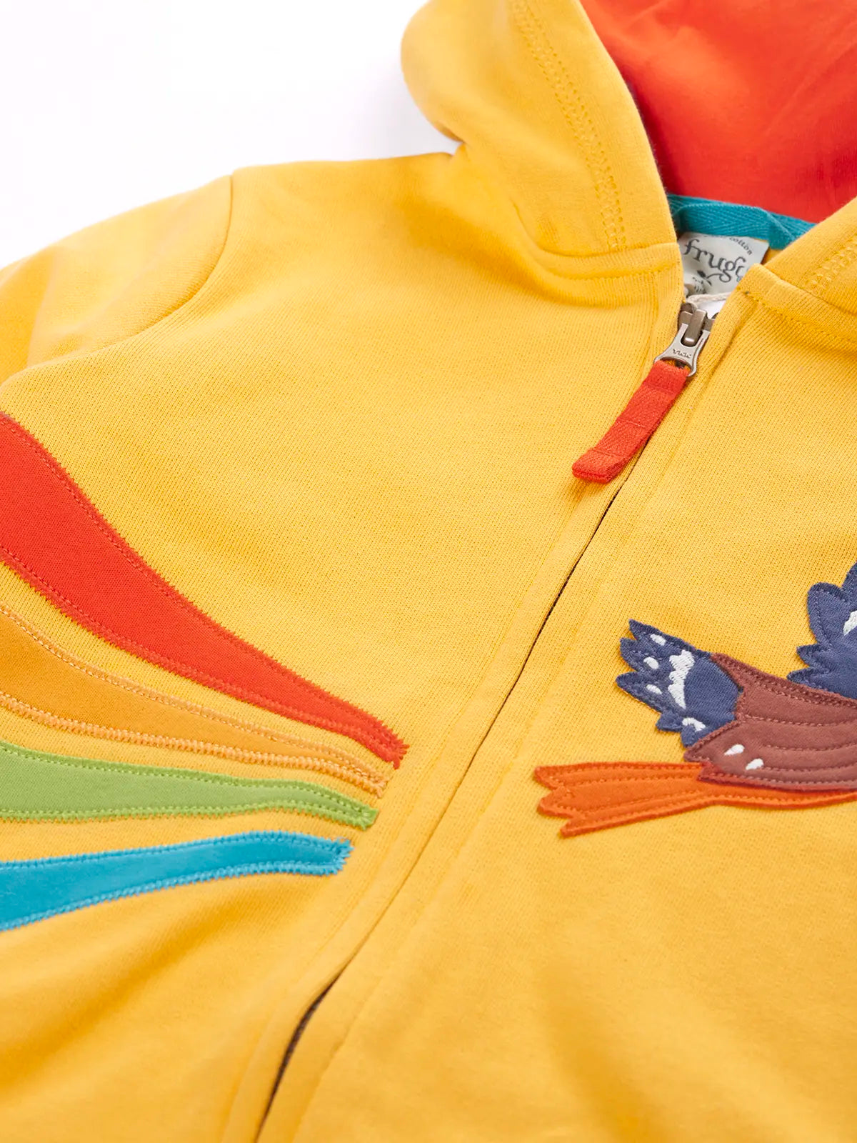 Close up of the zip and orange cotton zip pull on the Frugi organic cotton blaire zip hoodie in bumblebee yellow with eagle applique.