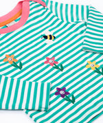 A close up of the embroidered  flower and bee details on the front of the Frugi Orion flowers long sleeved, organic cotton kids top. 