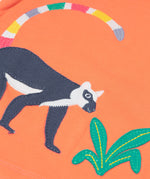 Close up of the Frugi Rownenna outfit, lemur laugh. Showing the appliqué of a lemur next to green leaves on coral organic cotton fabric
