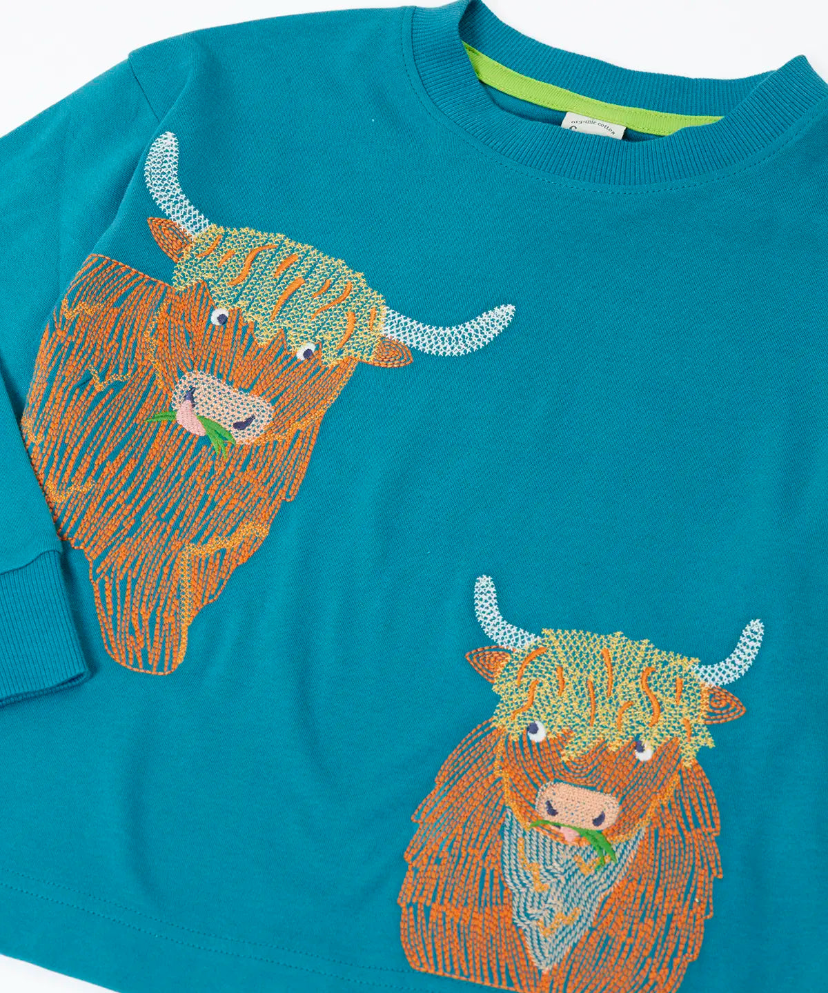 Close up of the details on the highland cow embroidery on the Frugi Owen long sleeve top in boat blue.
