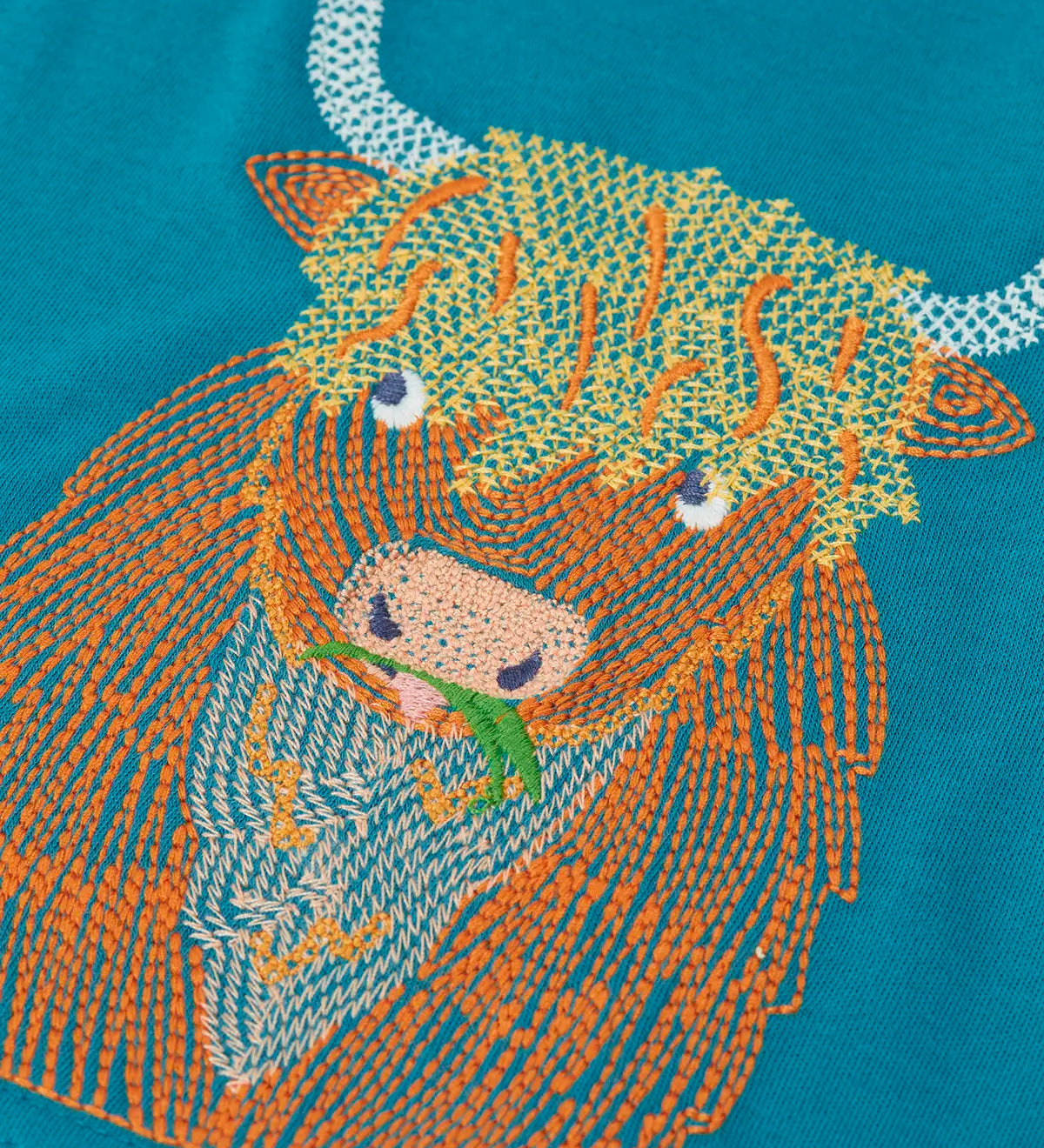 Close up of the details on the highland cow embroidery on the Frugi Owen long sleeve top in boat blue.
