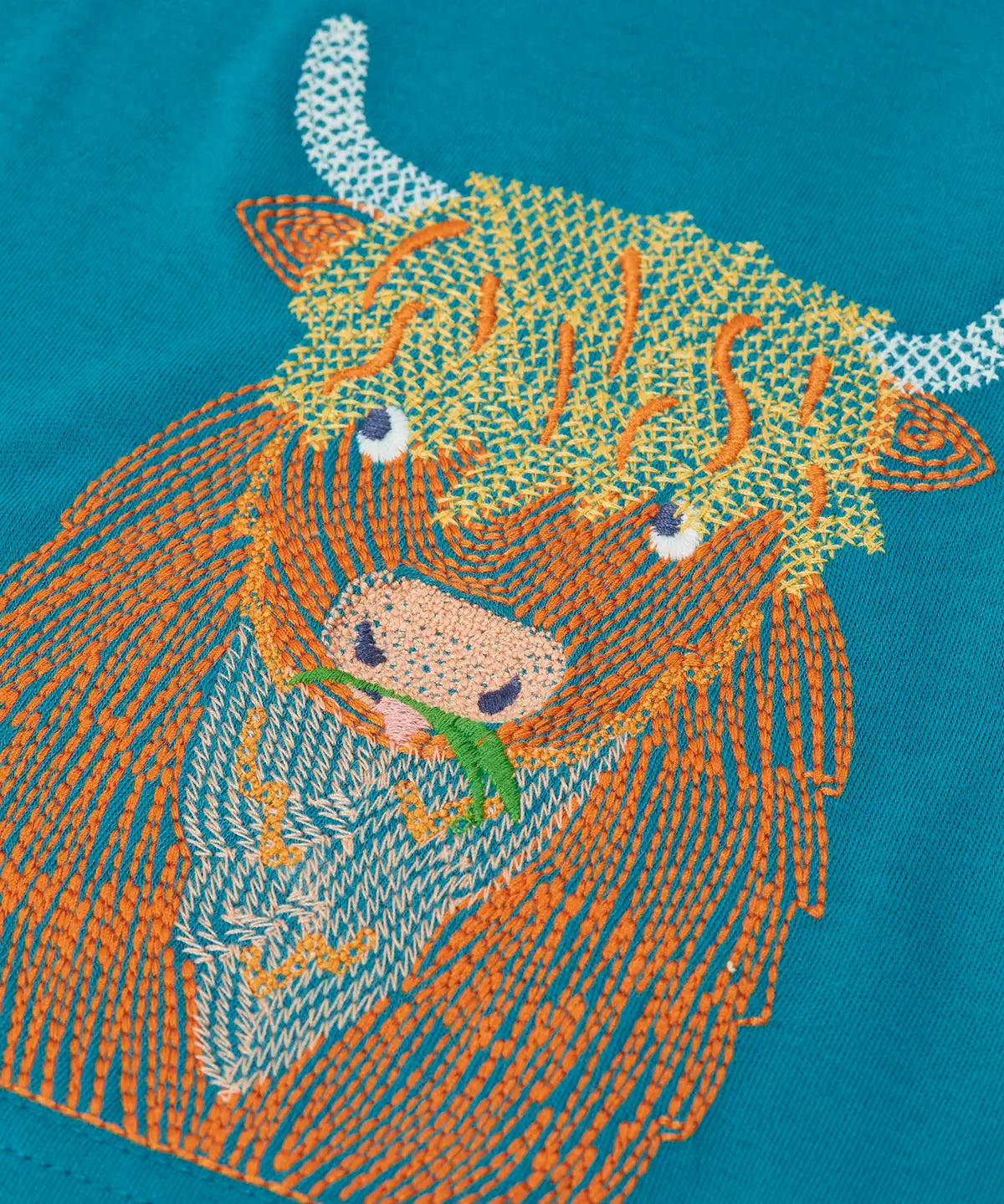 Close up of the details on the highland cow embroidery on the Frugi Owen long sleeve top in boat blue.