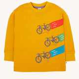 Frugi Owen top in a yellow gold colour featuring a bicycle design on the front. Three embroidered bicycles each with different coloured applique roads behind them.