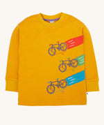 Frugi Owen top in a yellow gold colour featuring a bicycle design on the front. Three embroidered bicycles each with different coloured applique roads behind them.