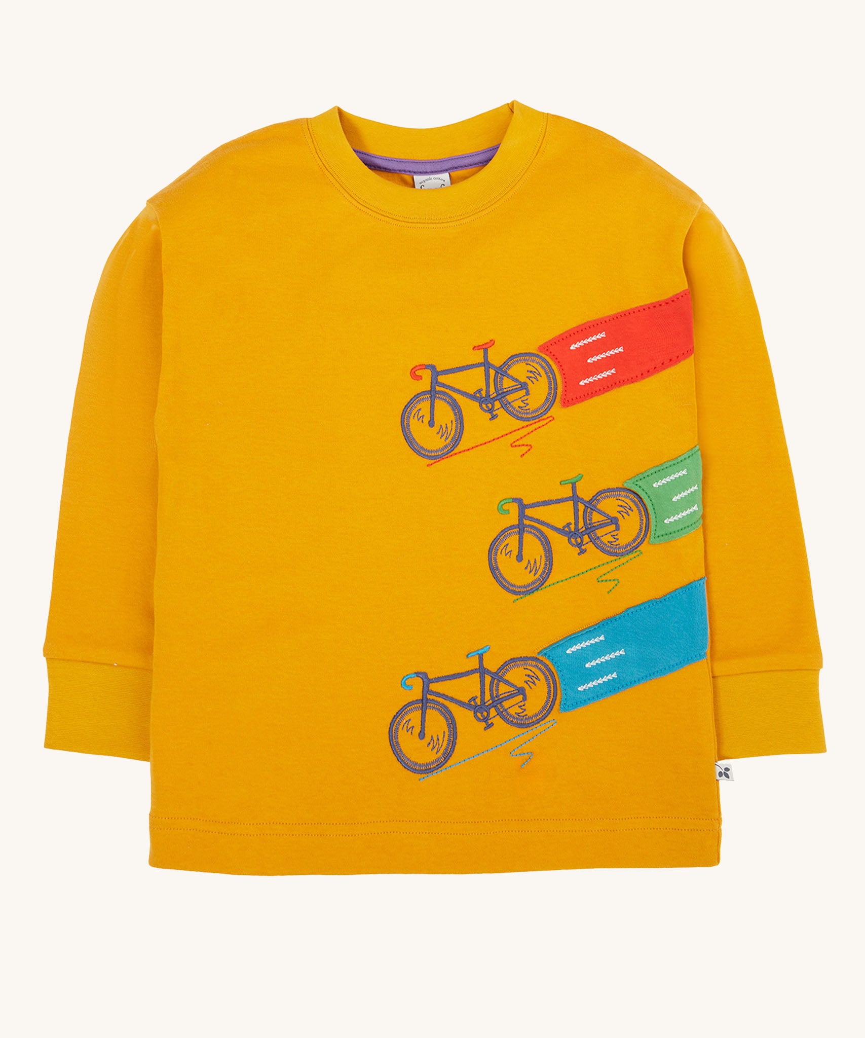 Frugi Owen top in a yellow gold colour featuring a bicycle design on the front. Three embroidered bicycles each with different coloured applique roads behind them.