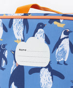 A close up of the Frugi kids pack a lunch bag in penguin waddle. Showing the name tag patch detail and orange trim