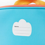 A close up of the Frugi kids pack a lunch bag in rainbow sun. Showing the name tag patch detail and yellow carry handle detail 